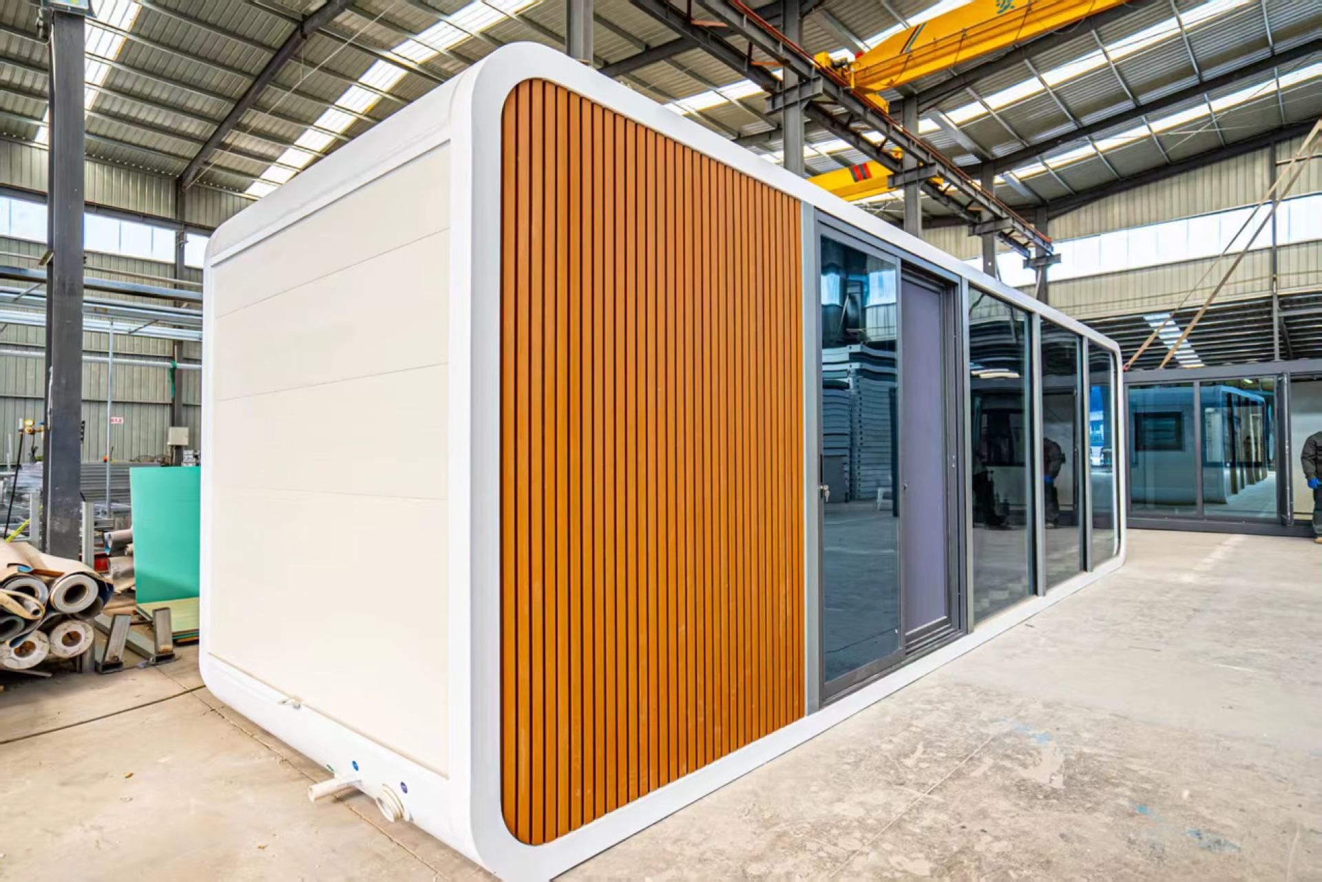 Finished Domicina prefabricated modular building on the factory floor with wood and glass elevation