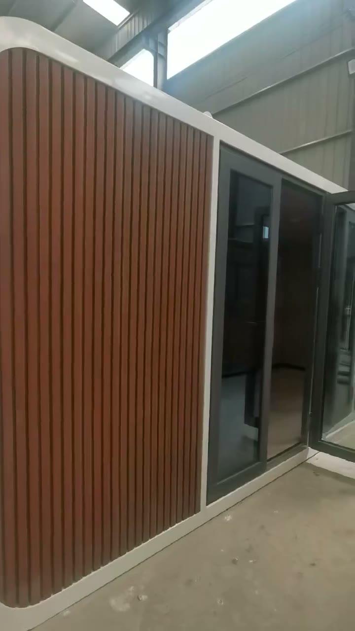 Interior of a Domicina prefabricated modular building with wood-lined walls and glass entry